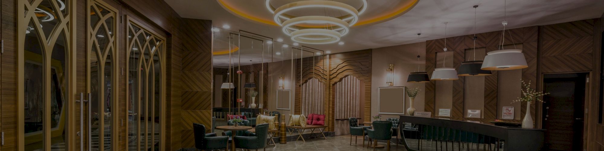 The image shows a modern, stylish restaurant interior with a large chandelier, elegant wooden decor, and a curved bar area.